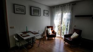a living room with a table and chairs and a window at Apartamento/Casa El Puente in Toledo