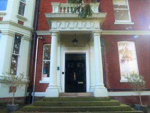 聖奧爾本斯的住宿－Torrington Hall，红砖建筑的前门,有柱子