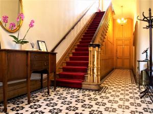 a staircase in a room with a red carpeted floor at Torrington Hall in Saint Albans