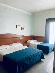 Habitación de hotel con 2 camas y ventana en Hotel Aurora en Milán