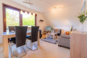 a dining room and living room with a table and chairs at Wohnung-D-306 in Böhl