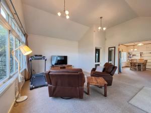 a living room with a couch and chairs and a tv at Country Garden Oasis with Parking and Wi-Fi in Taupaki