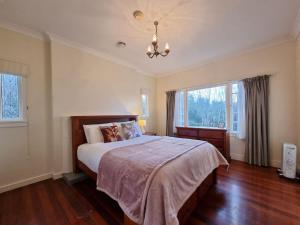 een slaapkamer met een bed en een groot raam bij Country Garden Oasis with Parking and Wi-Fi in Taupaki