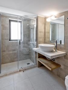 a bathroom with a sink and a glass shower at Villa AmberBlue Pefkos in Pefki