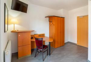 Habitación con escritorio y mesa con silla roja. en Heilbronner Hotel am schönen Theater en Heilbronn