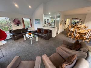 a living room with couches and a dining room at Luxury Home Next to Ocean and Walkway in New Plymouth