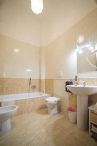a bathroom with a sink and a toilet and a tub at Casa Vacanze Naxos in Lido di Ostia