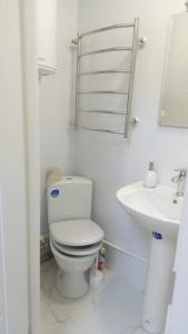 La salle de bains blanche est pourvue de toilettes et d'un lavabo. dans l'établissement Апартаменты WOW-hotel, à Kiev