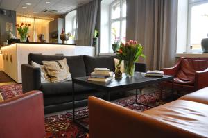 a living room with a couch and a table with books at Långholmen Hotell in Stockholm