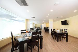 um restaurante com mesas e cadeiras e uma grande janela em Click Hotel Transport Nagar em Lucknow