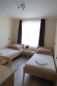 a bedroom with two beds and a desk at Péterfia Panzió in Debrecen