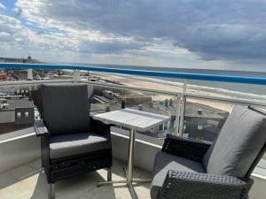 een balkon met een tafel en stoelen en de oceaan bij Droomvakanties Egmond Zeezicht in Egmond aan Zee +2 foto's