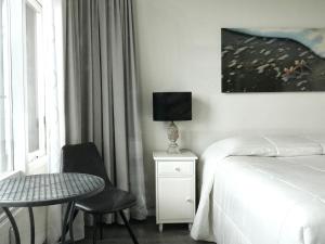 a hotel room with a bed and a table and chair at Droomvakanties Egmond Zeezicht in Egmond aan Zee