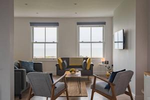 a living room with a couch and a table at The Lookout - Stunning sea view apartment in Deal