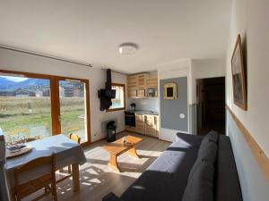a living room with a couch and a table at Les chalets de superD, apt 7-9 personnes in Le Dévoluy