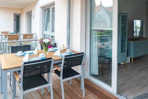 a wooden table and chairs on a balcony with a table at Heimathafen in Barth