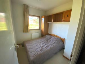 a small bedroom with a bed and a window at Les chalets de superD, apt 7-9 personnes in Le Dévoluy