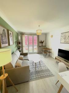 Le Châteaucreux - Cosy & SPA في سانت إتيان: غرفة معيشة مع أريكة وطاولة