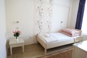 a bed in a room with a white bedspread at Péterfia Panzió in Debrecen