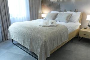 a bedroom with a bed with two towels on it at Apartament Prywatny Stone Hill Rackiewicz z basenem in Szklarska Poręba