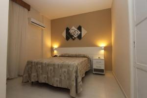 a small bedroom with a bed and a night stand at Gonzaga Flat in Santos