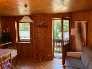 a living room with a couch and a table and a television at La Majonetta in Champoluc