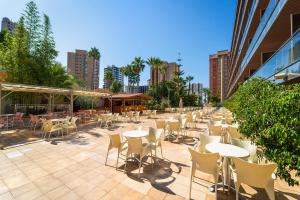 uma fila de mesas e cadeiras num pátio em Hotel Servigroup Diplomatic em Benidorm