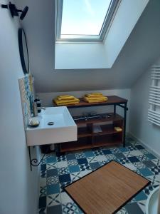 ein Badezimmer mit einem Waschbecken und einem Dachfenster in der Unterkunft En pleine campagne, proche du Mans - chambre d'hôtes in Fillé