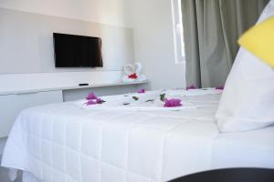 a white bed with flowers on top of it at Porto de Galinhas Blue Sky in Porto De Galinhas