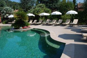 - une piscine avec des chaises et des parasols sur une terrasse dans l'établissement Domaine De Respelido, à Carros