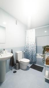 a white bathroom with a toilet and a sink at Nordik Rooms Village - Chilches "Taby" in Vélez-Málaga