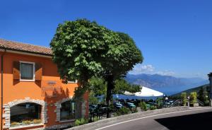 un árbol frente a un edificio con un árbol en Hotel Giardinetto, en San Zeno di Montagna