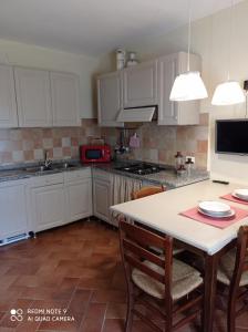 een keuken met witte kasten en een tafel met stoelen bij Agula Relais appartamento in Pugnano