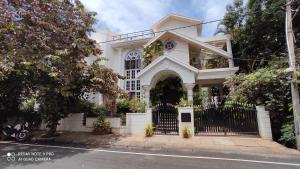 a white house with a black gate at Abode in Bangalore