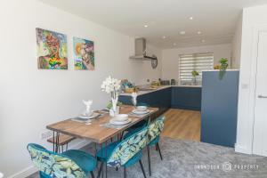 a kitchen and dining room with a wooden table and chairs at Beautifully Modern 3 bed House, Parking, Poole - Copenhaven in Poole