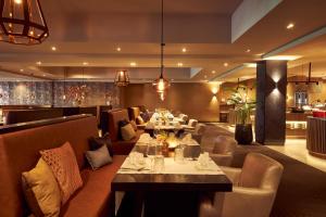um restaurante com mesas e sofás numa sala em Van der Valk Hotel Groningen Zuidbroek em Zuidbroek