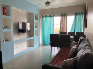 sala de estar con sofá y TV en Vista mar, duplex a 20 mts praia do forte, jacuzzi e wifi, en Cabo Frío