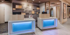 eine Lobby mit zwei blauen Bildschirmen in einem Gebäude in der Unterkunft Holiday Inn Express & Suites - Lumberton, an IHG Hotel in Lumberton