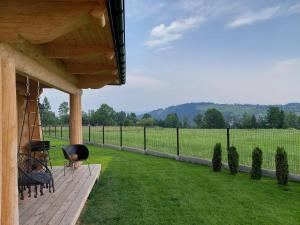 a porch of a house with a view of a field at WIOSKA RUSIŃSKI in Bukowina Tatrzańska