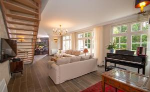 uma sala de estar com um sofá branco e um piano em maison d'hôtes ed.André 10 personnes em Azay-sur-Cher