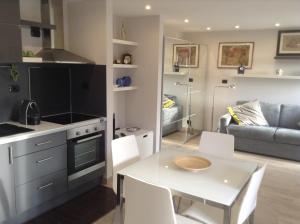 una cucina e un soggiorno con tavolo e sedie bianchi di Chambre d'Hôtes "La Cabrière" a Salernes