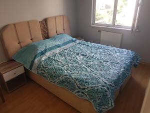 um quarto com uma cama com uma colcha azul em Blue Appartment near to Istanbul new Airport em Istambul