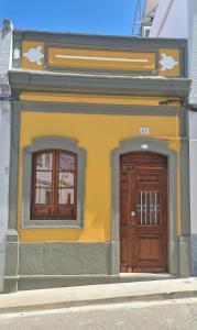 a building with two doors and two windows at Different House Holidays in Fuzeta