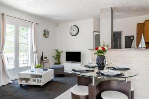 uma sala de estar branca com uma mesa e cadeiras em Le Petit Thao em Fréjus