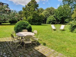 d'une terrasse avec une table et des chaises sur gazon. dans l'établissement Cottage authentique avec piscine, à Prunay-Cassereau