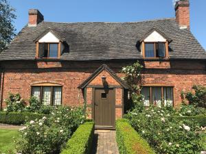 una casa de ladrillo rojo con puerta marrón en Hood Lane Farm B&B en Arley