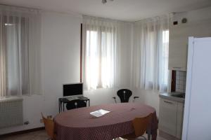 um quarto com uma mesa e uma cozinha com janelas em Casa per Venezia&Treviso em Treviso