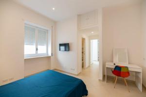 1 dormitorio con cama azul y escritorio en Marina Grande Holiday Apartment in Capri, en Capri