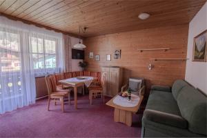 uma sala de estar com um sofá, uma mesa e cadeiras em Gästehaus Schernthaner em Dorfgastein