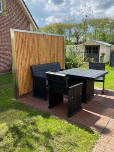 a picnic table and two chairs in a backyard at FeWo Ostsee Ahoi in Timmendorfer Strand